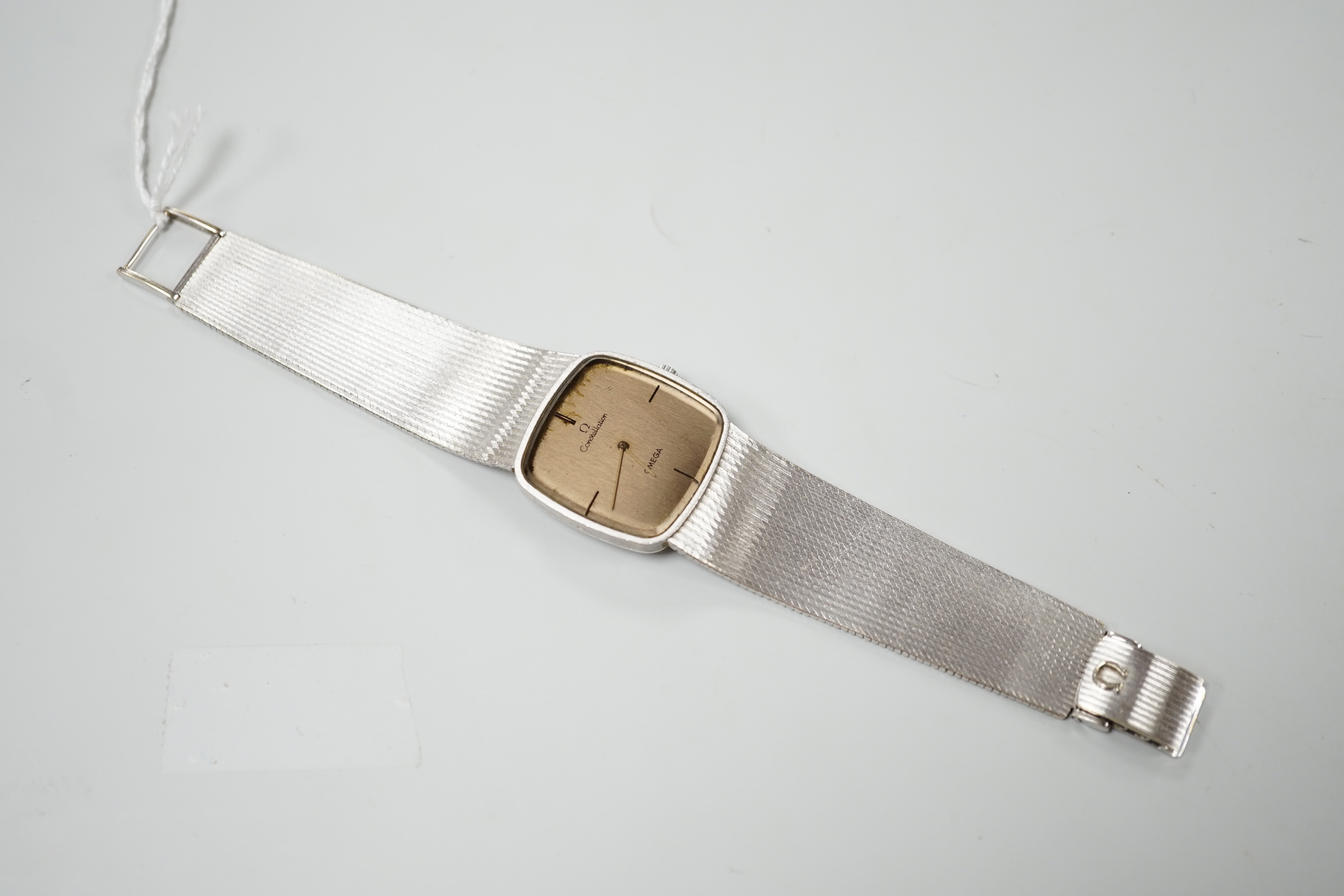 A gentleman's 1970's 750 white metal Omega Constellation manual wind dress wrist watch, on integral 750 Omega bracelet, movement c.700, with part paperwork, overall 18.3cm, gross weight 75.1 grams.